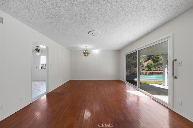 spare room featuring a textured ceiling, wood finished floors, and a healthy amount of sunlight