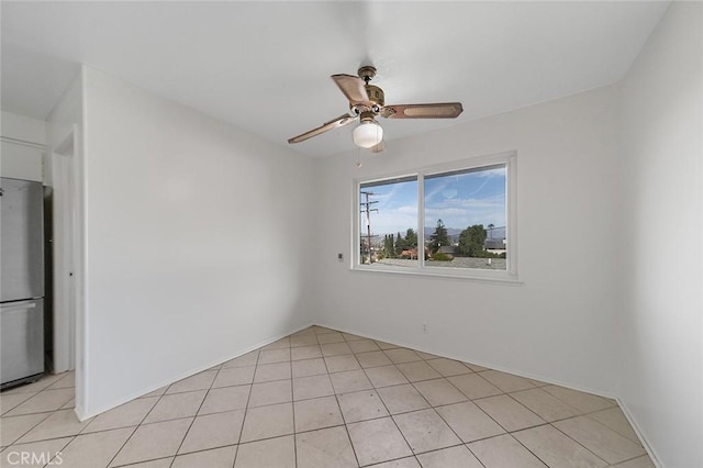 spare room with a ceiling fan and light tile patterned flooring