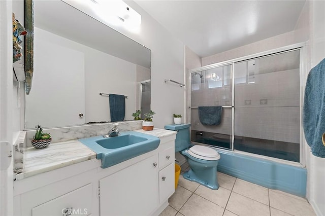 full bath featuring toilet, shower / bath combination with glass door, vanity, and tile patterned floors