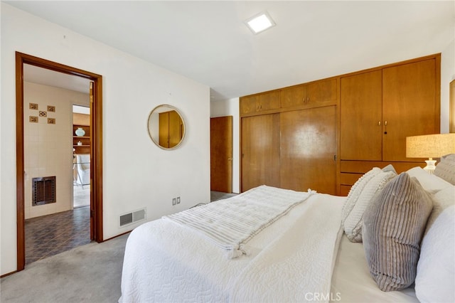 bedroom featuring a closet, visible vents, and light colored carpet