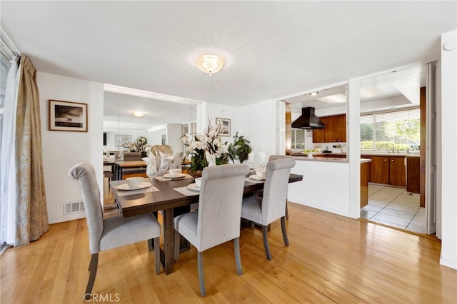 dining area with visible vents and light wood-style floors