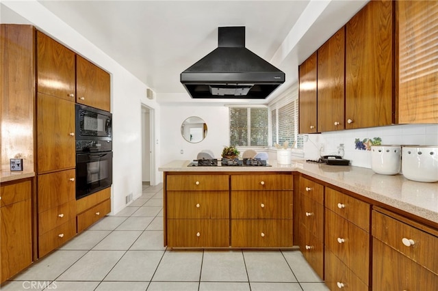 kitchen featuring light tile patterned floors, black appliances, custom exhaust hood, and brown cabinets