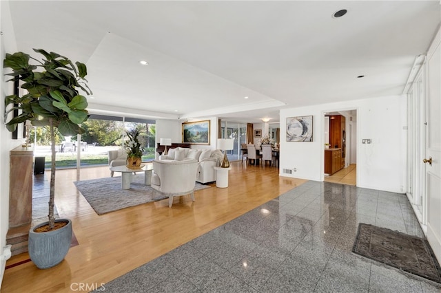 living room with recessed lighting, visible vents, and granite finish floor