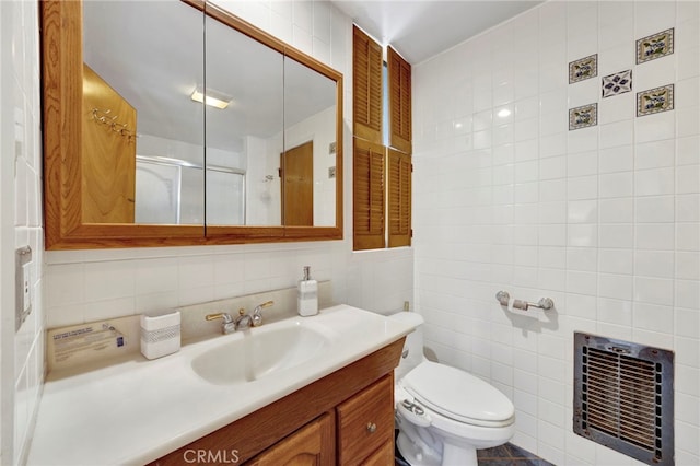 full bath featuring toilet, heating unit, an enclosed shower, vanity, and tile walls