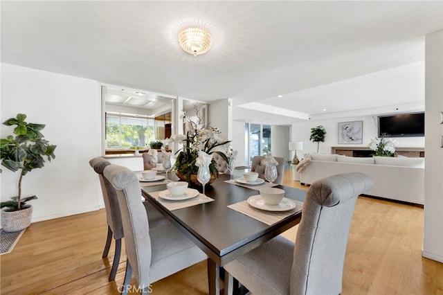 dining area featuring light wood-style flooring and baseboards