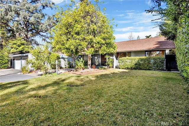 view of front of home with driveway, a front lawn, and stucco siding