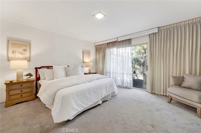 bedroom with light carpet and access to outside