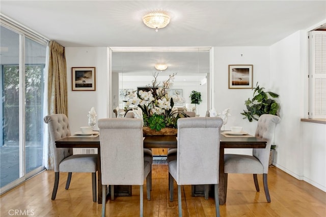 dining space with expansive windows and wood finished floors