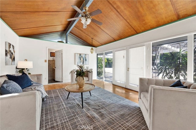 living area featuring vaulted ceiling with beams, wood ceiling, ceiling fan, and wood finished floors