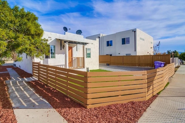 view of front of house featuring a fenced front yard and stucco siding