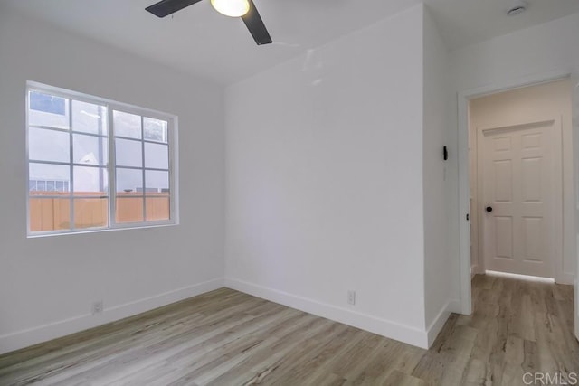 unfurnished room with ceiling fan, light wood-style flooring, and baseboards