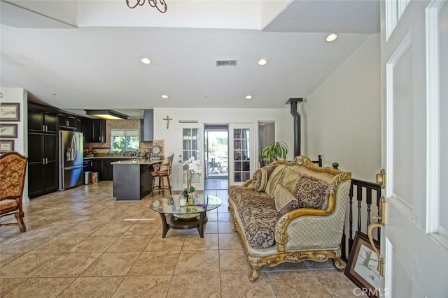 living area with recessed lighting, a wood stove, visible vents, and light tile patterned flooring