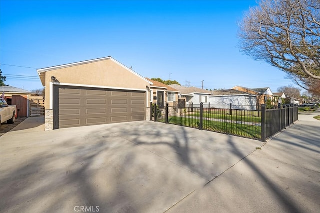 view of front of house with a fenced front yard, a residential view, a detached garage, and stucco siding