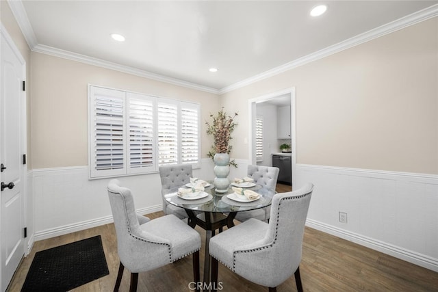 dining room with dark wood-type flooring, recessed lighting, a wainscoted wall, and ornamental molding