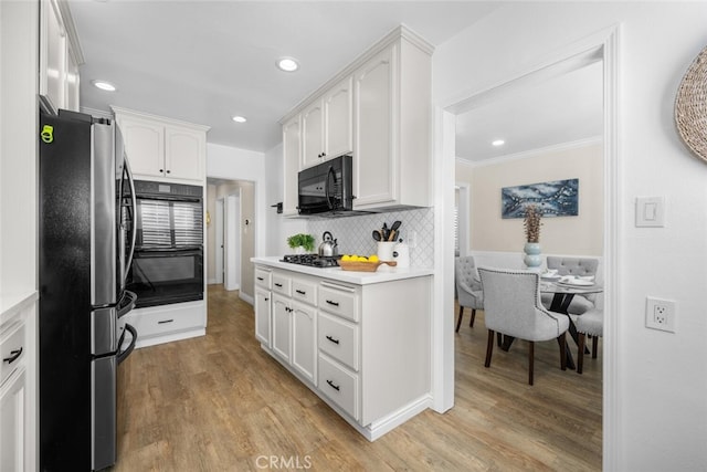 kitchen with white cabinets, light countertops, and black appliances