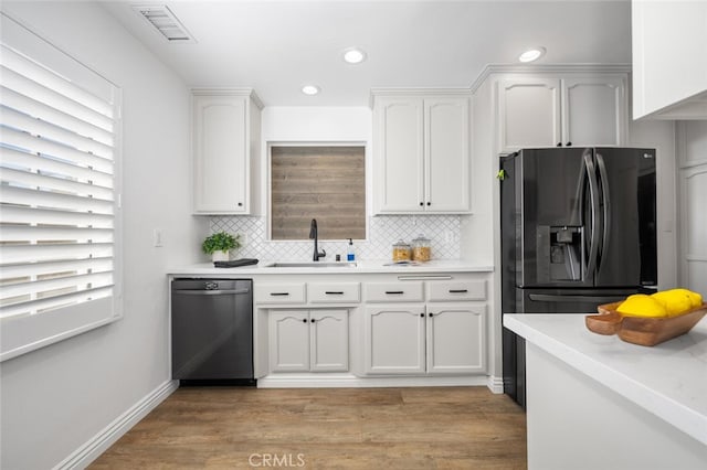 kitchen featuring a sink, visible vents, white cabinetry, light countertops, and dishwasher