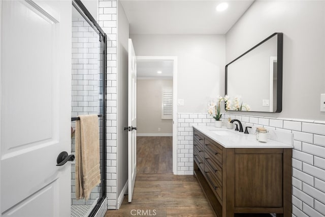 bathroom featuring recessed lighting, a wainscoted wall, wood finished floors, vanity, and tile walls