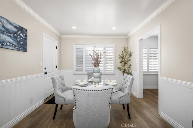 dining space featuring a wainscoted wall, ornamental molding, and dark wood-style flooring