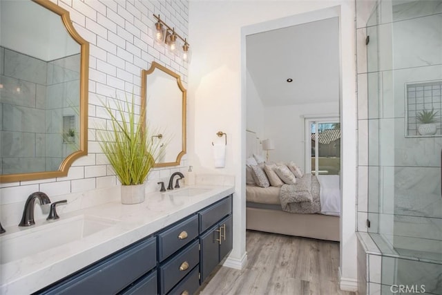 ensuite bathroom featuring double vanity, wood finished floors, ensuite bath, and a sink