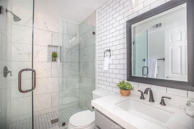 full bath with tasteful backsplash, visible vents, vanity, a shower stall, and tile walls