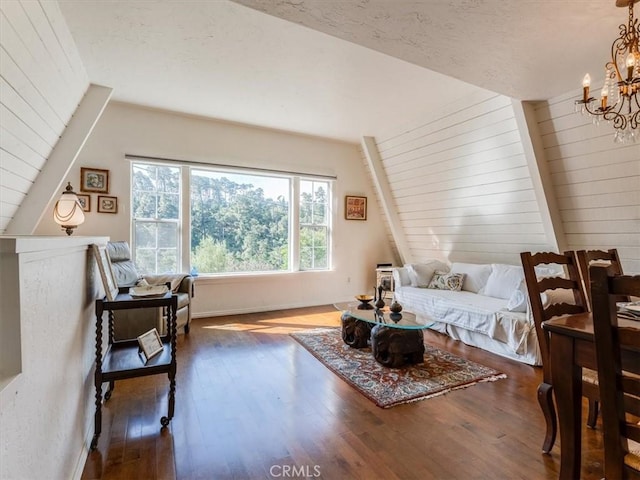 bedroom with a textured ceiling, baseboards, dark wood finished floors, and a notable chandelier