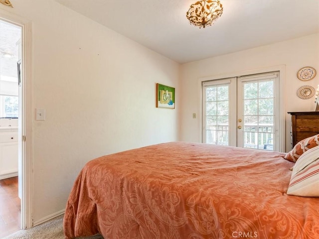 bedroom featuring access to outside, french doors, and baseboards