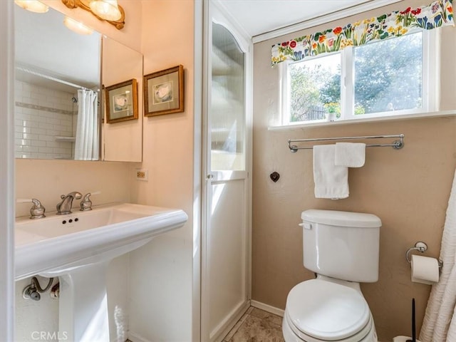 full bathroom with tile patterned flooring, toilet, a shower with shower curtain, a sink, and baseboards