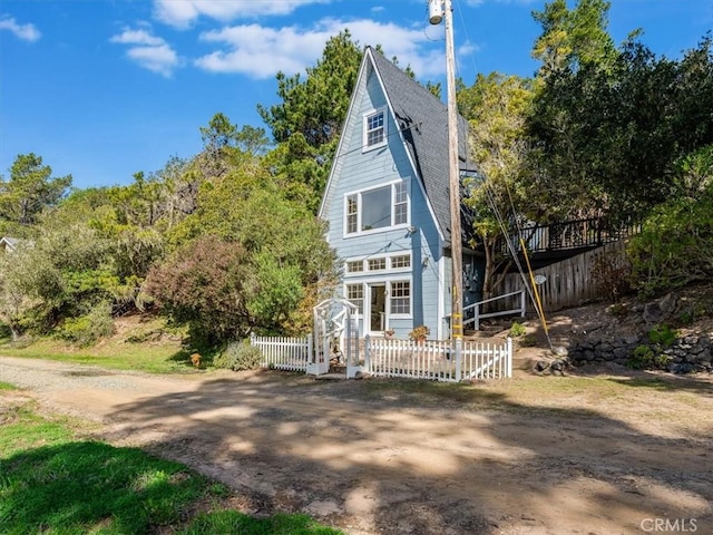 a-frame style home with fence