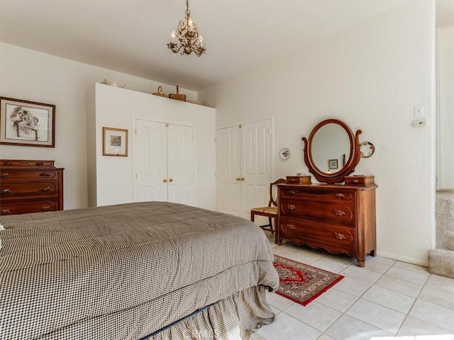 bedroom with a closet, baseboards, a notable chandelier, and light tile patterned flooring