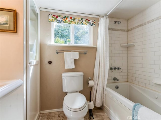 full bath featuring shower / bath combo, tile patterned floors, toilet, and baseboards