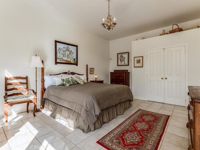 bedroom with light tile patterned floors, a closet, a chandelier, and lofted ceiling
