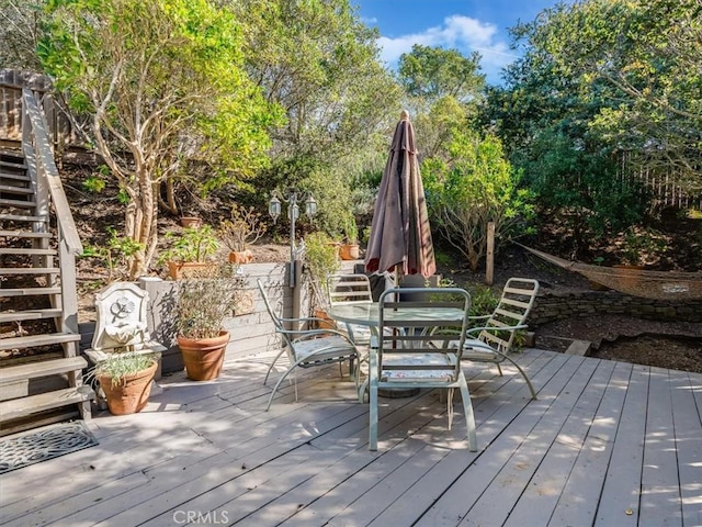 deck with outdoor dining space and stairway