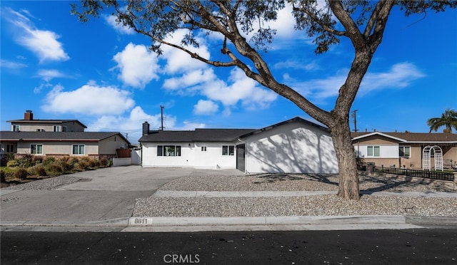 view of front of home with driveway and fence