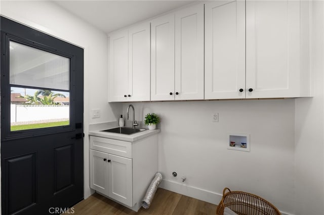 laundry area with hookup for a gas dryer, washer hookup, a sink, cabinet space, and dark wood finished floors