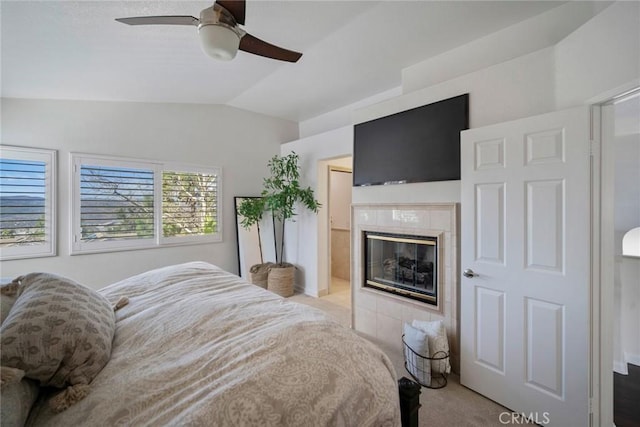 bedroom featuring lofted ceiling, ceiling fan, a fireplace, and light colored carpet