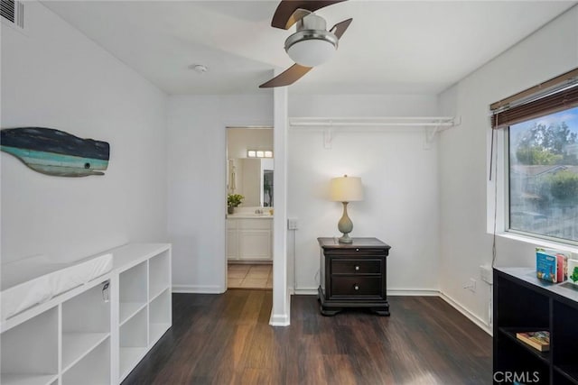 interior space with dark wood-style floors, visible vents, connected bathroom, ceiling fan, and baseboards