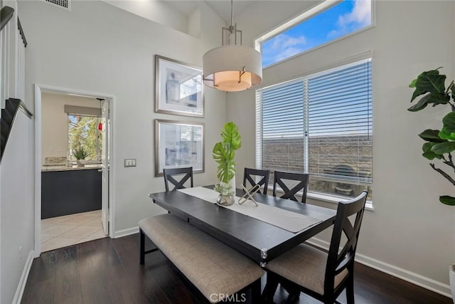 dining space featuring dark wood-type flooring and baseboards