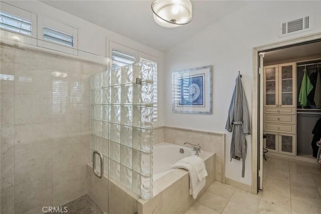 bathroom featuring a garden tub, visible vents, vaulted ceiling, tile patterned floors, and a stall shower