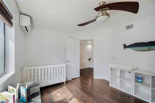 bedroom featuring visible vents, dark wood-type flooring, a ceiling fan, an AC wall unit, and baseboards