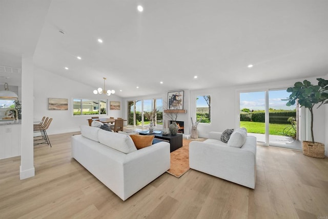 living room with a warm lit fireplace, recessed lighting, a notable chandelier, and light wood-style floors