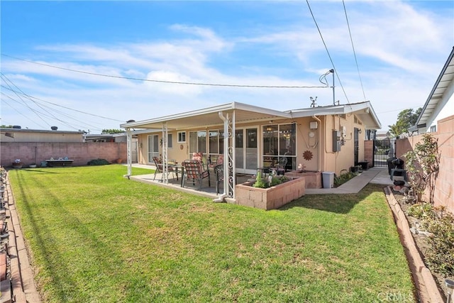 back of property with a lawn, a patio area, a fenced backyard, and a gate