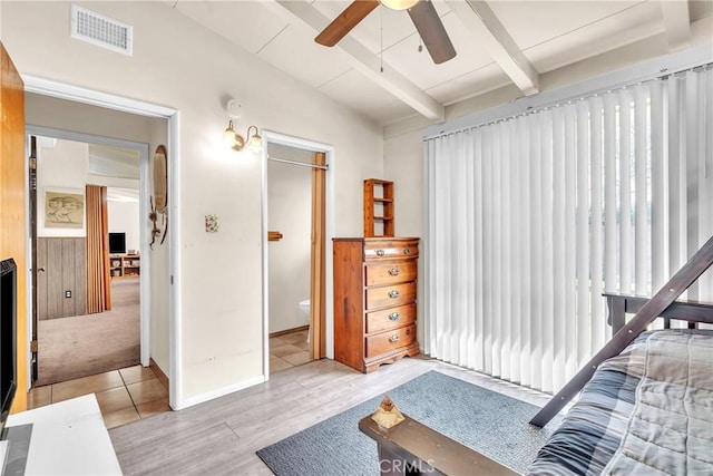 bedroom with ceiling fan, vaulted ceiling with beams, visible vents, baseboards, and light wood finished floors