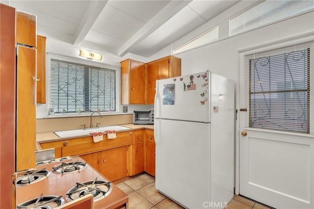 kitchen with white appliances, light countertops, a sink, and light tile patterned flooring