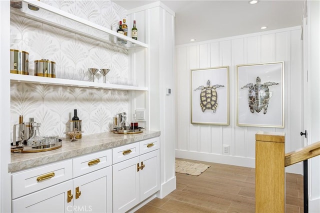 bar with light wood-type flooring, baseboards, recessed lighting, and wallpapered walls