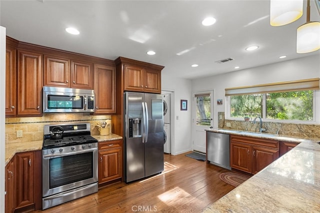 kitchen with light stone countertops, visible vents, stainless steel appliances, and a sink