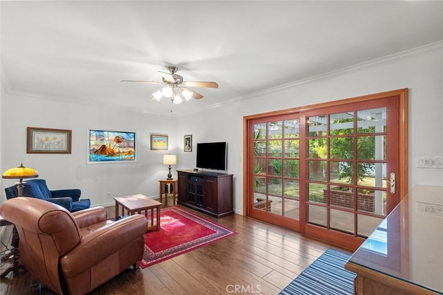 living room featuring baseboards, a ceiling fan, dark wood finished floors, and crown molding