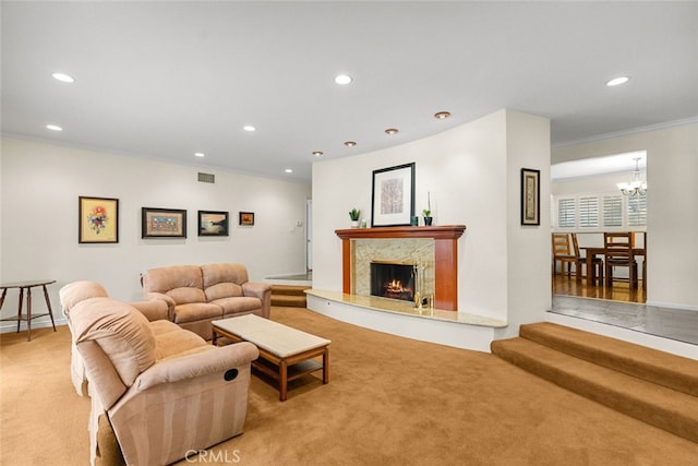 living room with crown molding, recessed lighting, light colored carpet, visible vents, and a high end fireplace