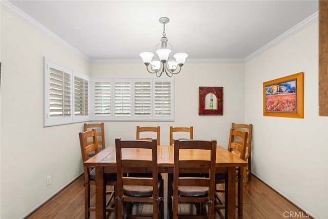 dining area with ornamental molding, a notable chandelier, and wood finished floors