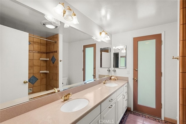 full bathroom with double vanity, a sink, toilet, and tile patterned floors