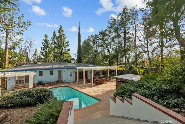 rear view of house with a patio area and an outdoor pool